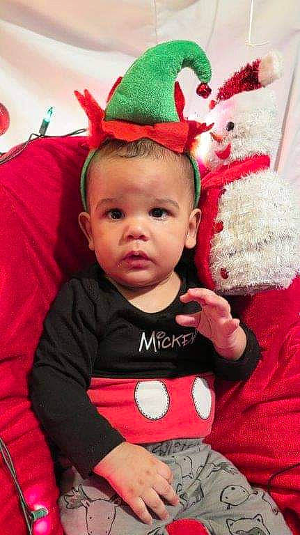 Hakim participe au concours pour gagner de l'argent avec cette photo : arm, baby, baby_toddler_clothing, cap, child, costume_hat, event, eye, fictional_character, happy, hat, head, headgear, human_body, lap, person, pink, red, sleeve, toddler