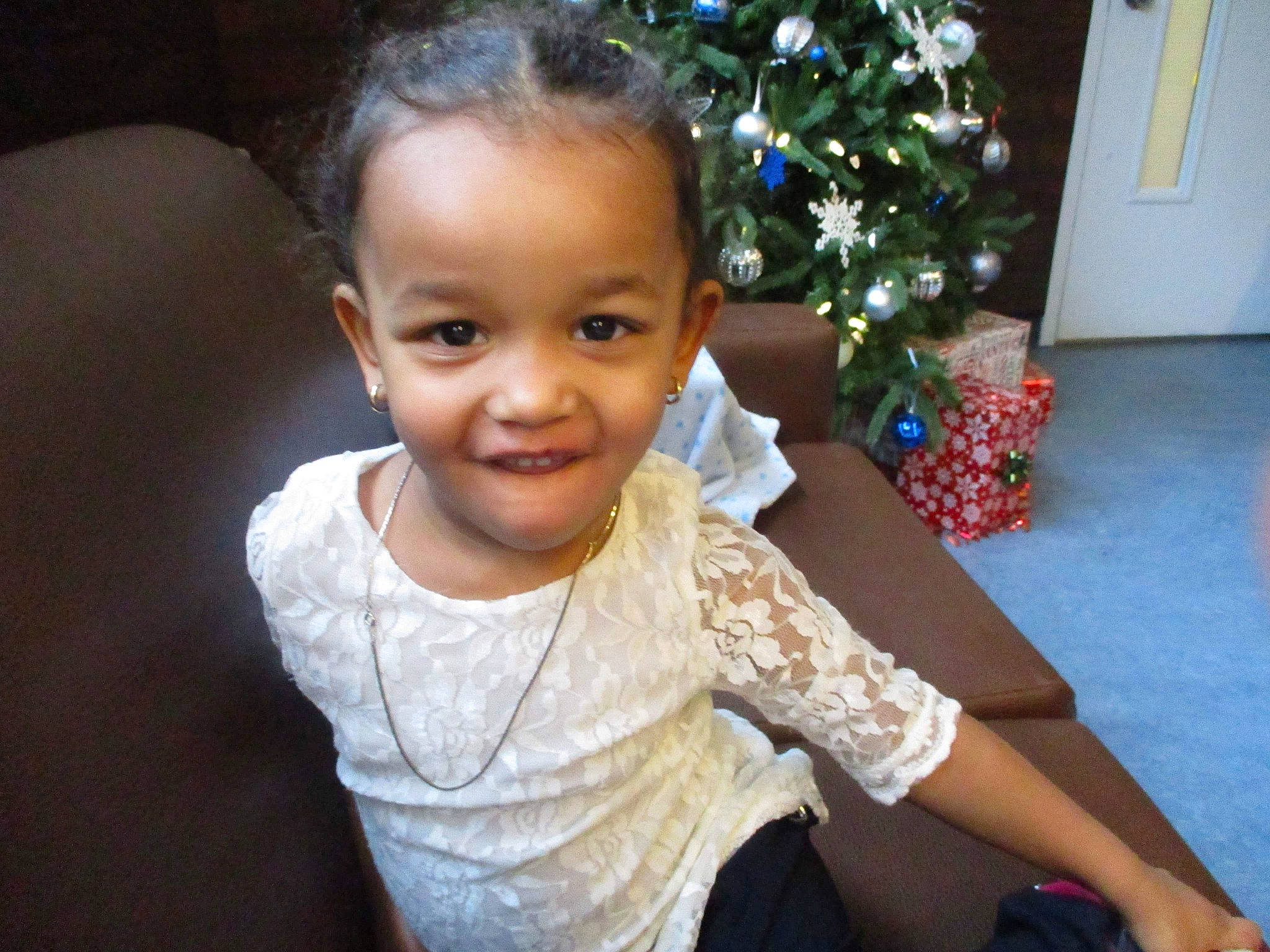 Havilah participe au concours pour gagner de l'argent avec cette photo : baby_toddler_clothing, cheek, christmas_ornament, christmas_tree, dress, eye, face, fun, hair, happy, head, iris, joy, ornament, person, plant, skin, sleeve, smile, standing