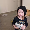 toddler, child, smiling, batman_shirt, black_beanie, game_controller, indoor, carpet, toy, motion_blur, happy, person, young_child, playful, cute, hair, clothing, headwear, fun, living_room