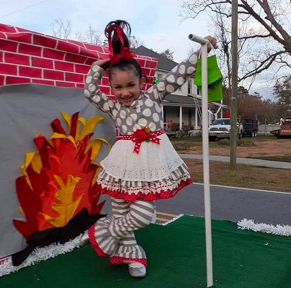 Christiana is registered to the contest to win money with this photo: costume, dance, dress, entertainment, event, fun, grass, hat, joy, leisure, performing_arts, person, petal, pink, plant, pole, recreation, shoe, sky, smile