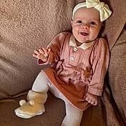 Willow joined the competition — help win amazing prizes! baby, infant, smile, headband, bow, pink_dress, tights, fluffy_booties, cozy, blanket, soft_texture, happy, cute, child, portrait, indoor, comfortable, small_hands, couch, relaxed