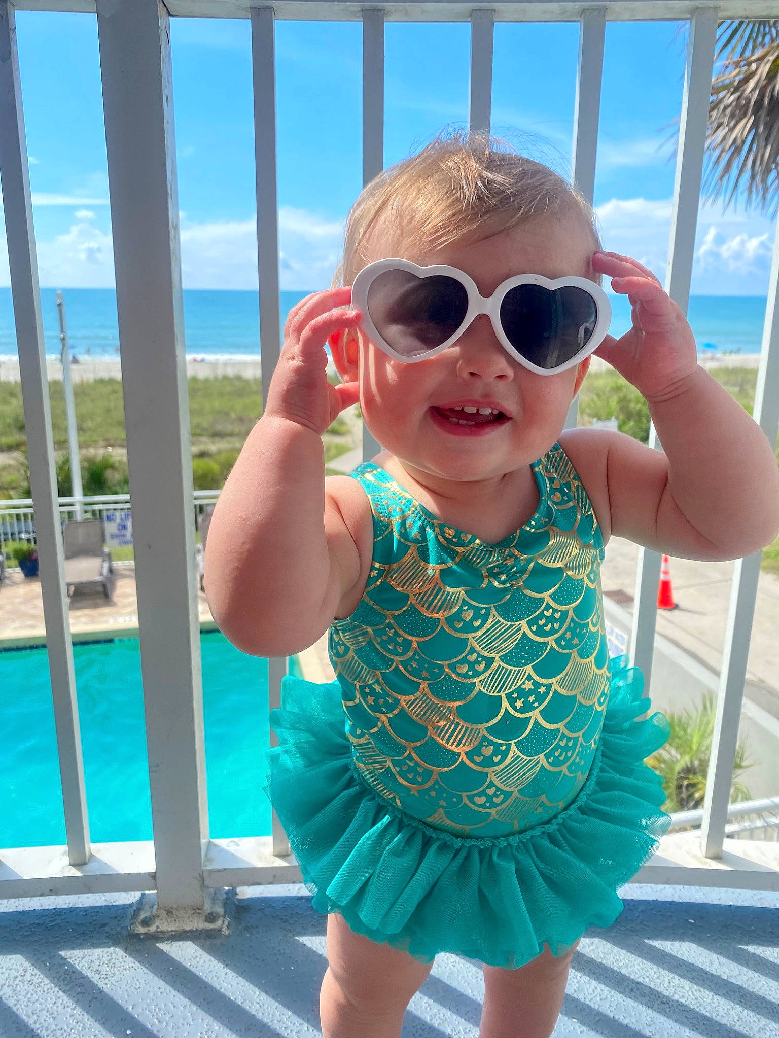 Lauryn is registered to the contest to win money with this photo: azure, baby, baby_toddler_clothing, blue, clothing, cloud, face, glasses, goggles, hairstyle, happy, head, neck, person, photograph, skin, sky, sleeve, standing, sunglasses