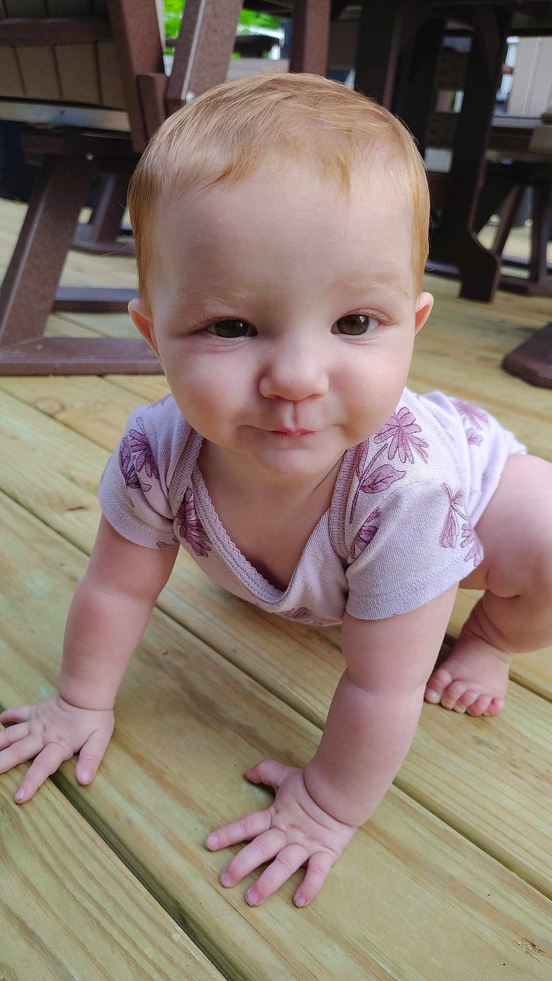 Penelope joined the competition — help win amazing prizes! baby, child, crawling, wooden_deck, outdoor, onesie, floral_pattern, curious, playful, light_hair, skin, hands, feet, furniture, background, closeup, portrait, person, infant, cute