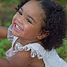 toddler, child, smiling, curly_hair, white_dress, lace, outdoor, greenery, portrait, happy, cute, baby, person, young_child, natural_light, closeup, face, joyful, playful, skin