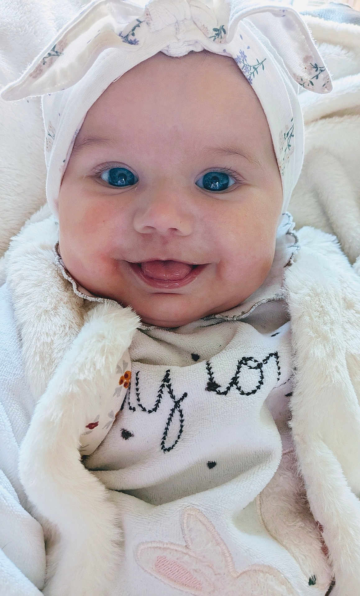 Safiya participe au concours pour gagner de l'argent avec cette photo : baby, infant, smiling, face, headband, bunny_ears, blue_eyes, close_up, cozy, blanket, soft_texture, cute, child, happy, portrait, clothing, indoor, young, adorable, expression