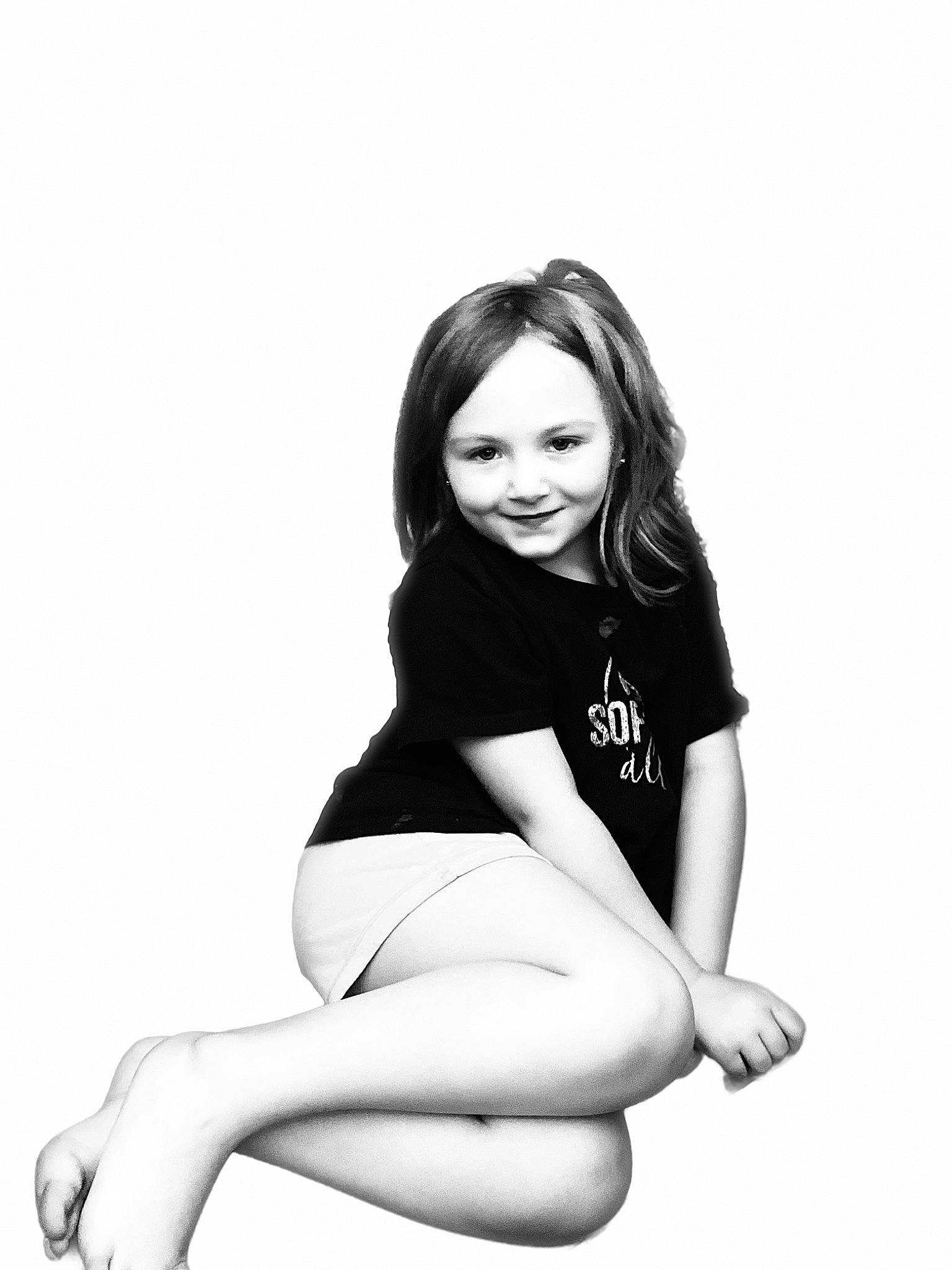 Kourtney is registered to the contest to win money with this photo: arm, black_hair, elbow, flash_photography, hair, happy, human_leg, joy, knee, leg, long_hair, monochrome, monochrome_photography, neck, person, shorts, sitting, sleeve, smile, style