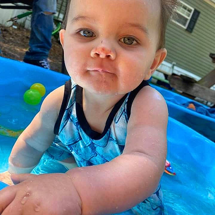 Negan is registered to the contest to win money with this photo: aqua, azure, baby, baby_toddler_clothing, blue, child, electric_blue, eyelash, finger, fun, grass, happy, leisure, person, product, recreation, sitting, smile, thumb, toddler