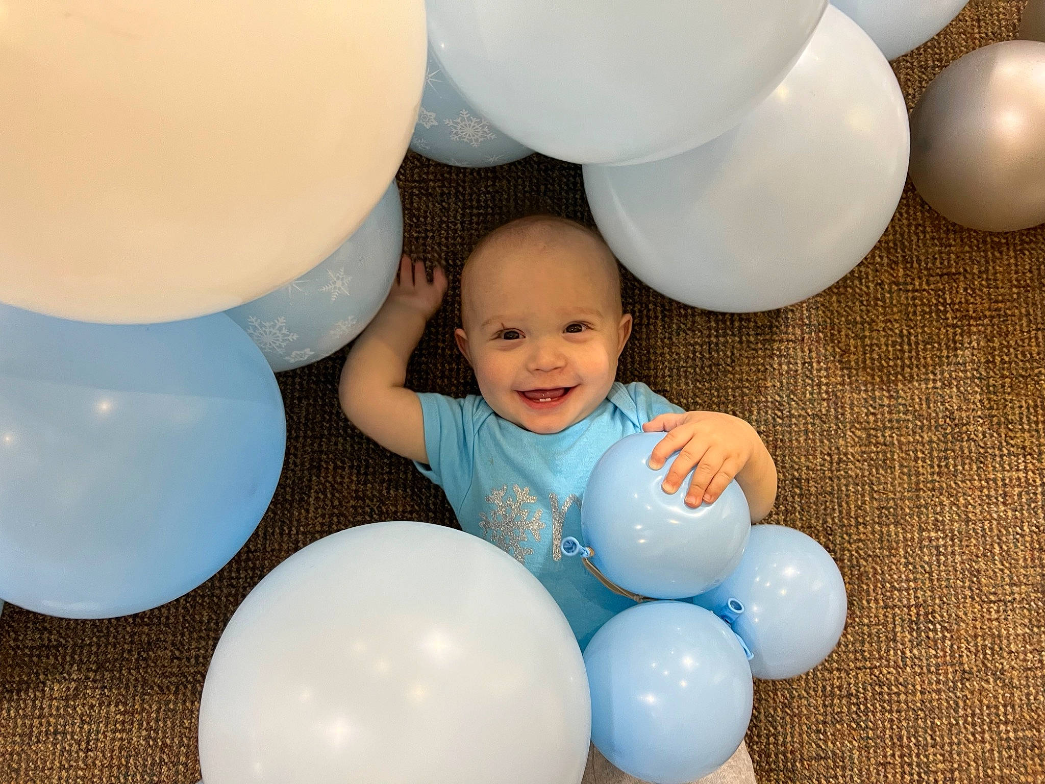 Ezra is registered to the contest to win money with this photo: baby, balloon, beauty, child, circle, electric_blue, event, fun, happy, joy, light, lighting_accessory, material_property, party, party_supply, person, product, sharing, smile, toddler