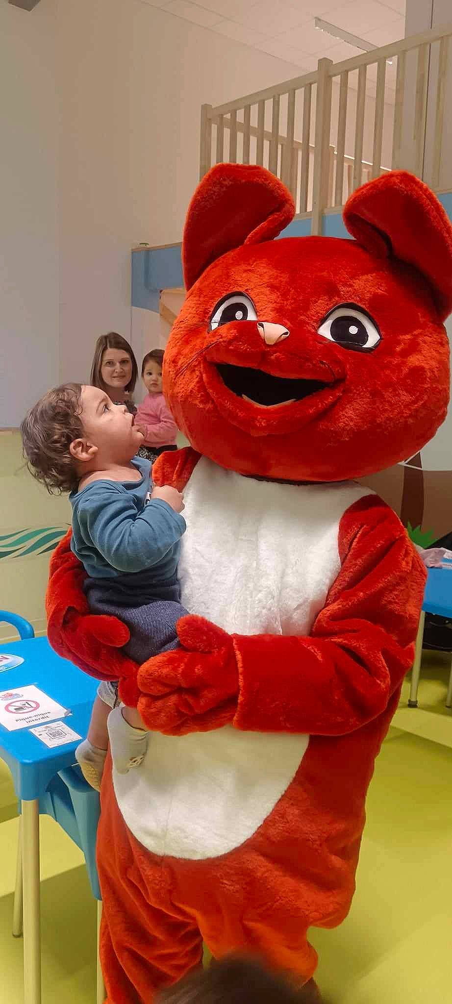 Ryad a rejoint le concours — aidez-le/la à gagner de superbes lots ! animation, child, costume, event, fun, fur, gesture, happy, head, joy, mascot, orange, organ, person, pink, plush, recreation, red, room, smile