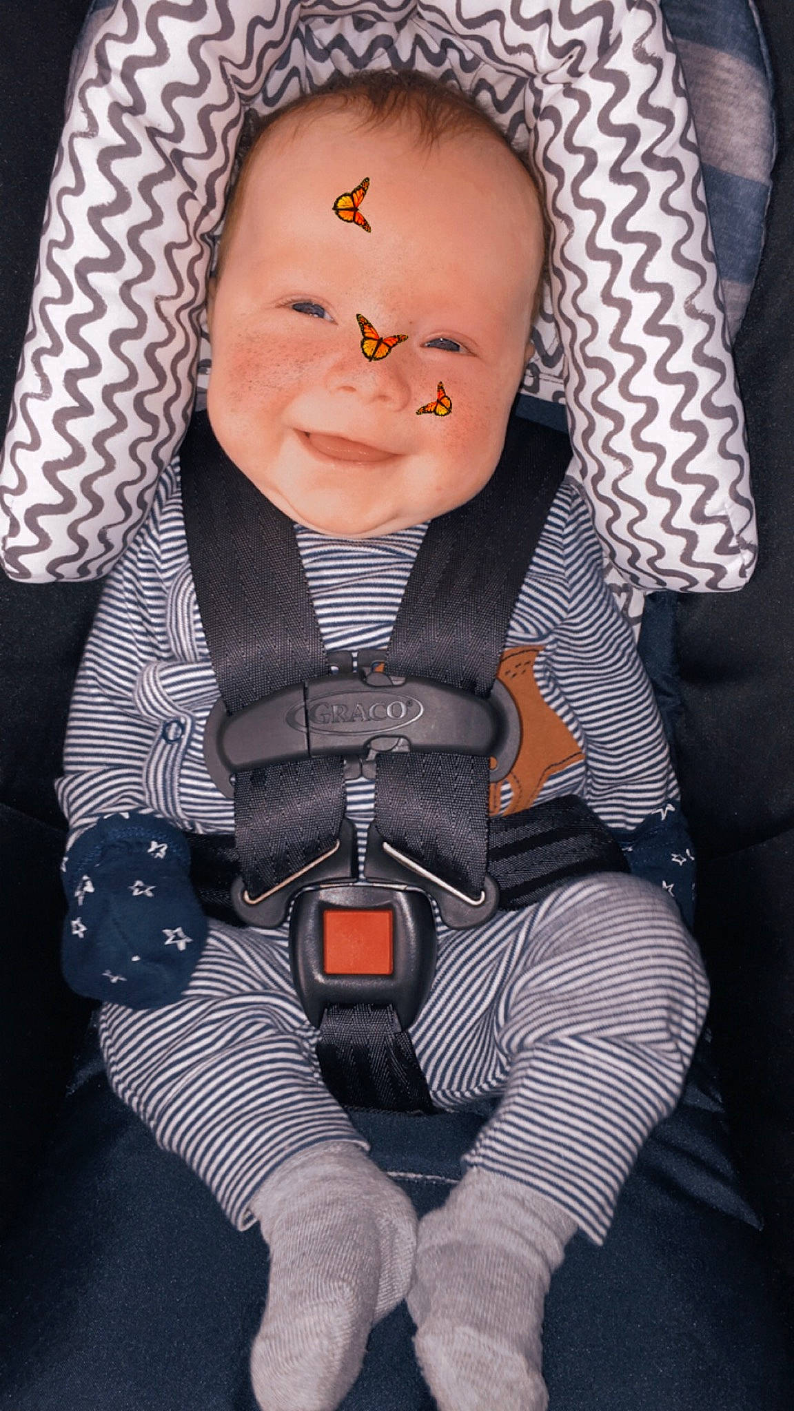 Theodore is registered to the contest to win money with this photo: baby, baby_carriage, baby_toddler_clothing, car_seat, cheek, child, comfort, cool, finger, happy, pattern, person, personal_protective_equipment, seat_belt, sitting, skin, sleeve, smile, textile, thumb