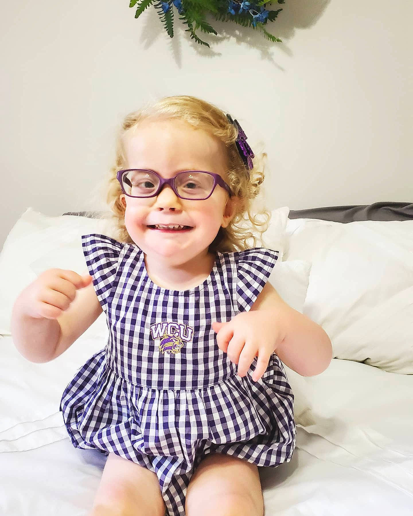 Lillie is registered to the contest to win money with this photo: baby, child, design, dress, eyewear, face, facial_expression, finger, glasses, head, joy, leg, lip, nose, pattern, person, photography, sitting, skin, smile