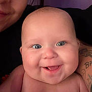 Serenity is registered to the contest to win money with this photo: baby, smiling, face, blue_eyes, tattoo, adult, closeup, skin, cheeks, happy, person, portrait, human, infant, expression, indoors, cute, naked_shoulder, background, head