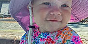 Alruna is registered to the contest to win money with this photo: baby, child, cute, daylight, floral_clothing, happy, hat, infant, lounge_chair, outdoor, palm_tree, person, poolside, portrait, smile, summer, sun_hat, sunny, swimsuit, water