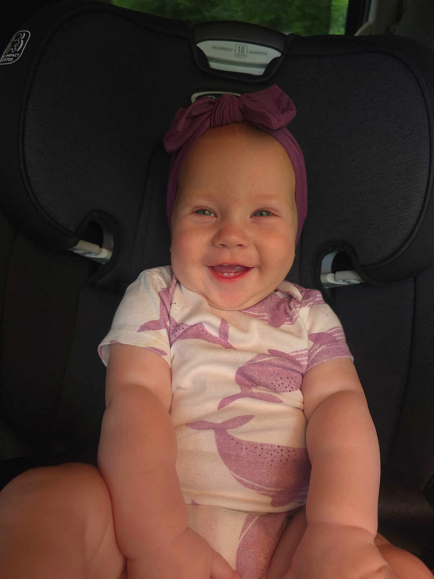 Alruna is registered to the contest to win money with this photo: baby, car_seat, child, closeup, clothing, cute, cute_expression, face, happy, headband, headwear, indoors, infant, person, portrait, seat, sitting, smiling, toddler, young_child