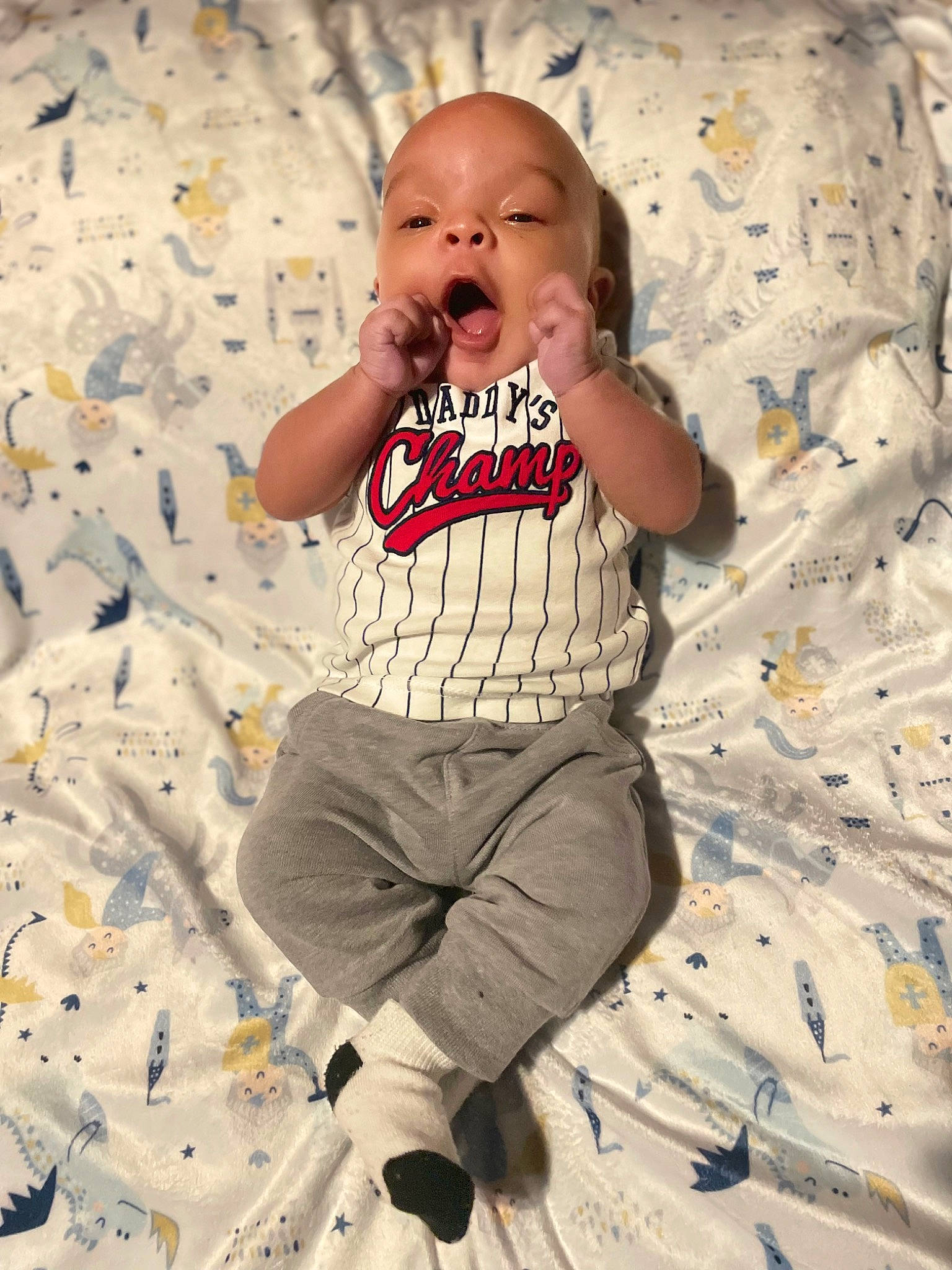 Richard is registered to the contest to win money with this photo: baby, baby_toddler_clothing, child, comfort, eye, face, fun, happy, linens, pattern, people_in_nature, person, play, sand, sitting, sleeve, standing, t_shirt, textile, toddler