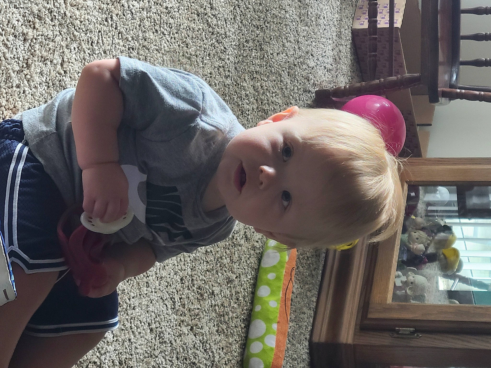 Jackson is registered to the contest to win money with this photo: baby, baby_toddler_clothing, child, eyewear, fun, grass, happy, leisure, person, play, sitting, smile, t_shirt, toddler, tree, vacation, wood