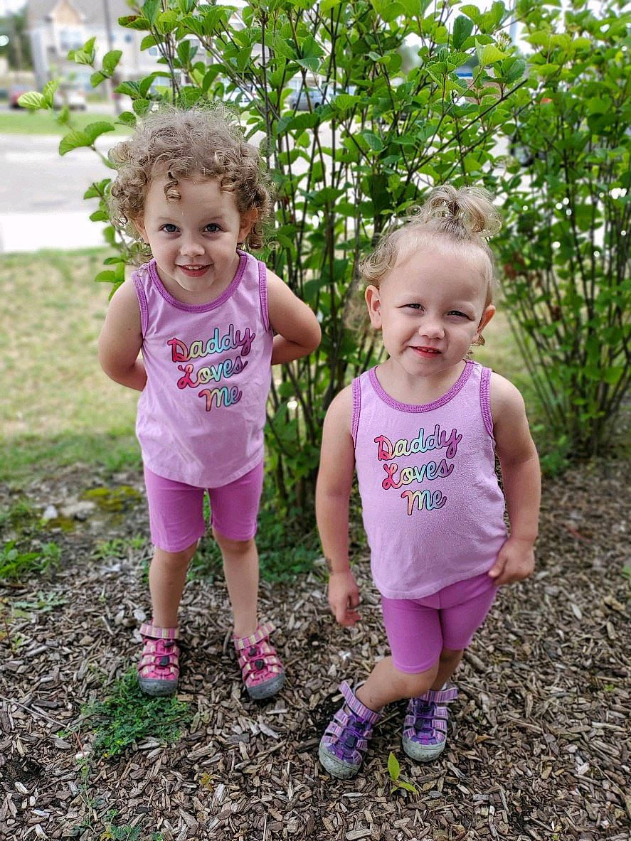 Novalee is registered to the contest to win money with this photo: baby_toddler_clothing, eye, face, facial_expression, footwear, fun, grass, hand, happy, iris, joy, leg, people_in_nature, person, pink, plant, shoe, shorts, smile, sneakers