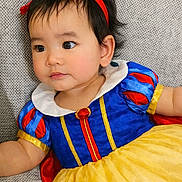 Sara joined the competition — help win amazing prizes! baby, infant, toddler, child, girl, costume, snow_white, red_bow, blue_dress, yellow_skirt, portrait, closeup, face, big_eyes, black_hair, sitting, couch, fabric, cute, indoor