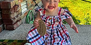 Mckenzie joined the competition — help win amazing prizes! baby, child, girl, dress, headband, bow, smiling, outdoor, porch, brick_wall, concrete, sunlight, grass, greenery, happy, sign, footwear, sitting, person, summer