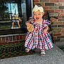 baby, child, girl, dress, headband, bow, plaid, sandals, porch, concrete, brick_wall, reflection, door, glass, welcome_mat, outdoor, smiling, holding, months_sign, happy