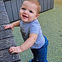 toddler, child, smiling, standing, blue_eyes, grey_tshirt, jeans, sneakers, wooden_bench, playground, outdoor, happy, person, casual_clothing, daylight, cute, young_child, holding, looking_up, fun