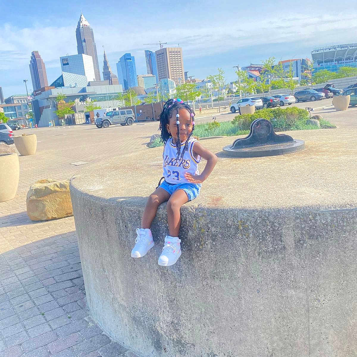 Zaina is registered to the contest to win money with this photo: architecture, building, car, child, city, cityscape, clothing, construction, constructioncrane, female, girl, horizon, landmark, nature, person, shorts, sitting, transportation, urban, vehicle
