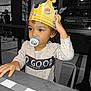 Nathanael participe au concours pour gagner de l'argent avec cette photo : baby, black_and_white_background, burger_king_crown, child, color_pop, curly_hair, cute, fast_food, food_court, indoor, long_sleeve_shirt, pacifier, person, restaurant, seat, smiling, table, toddler, waiting, young_child