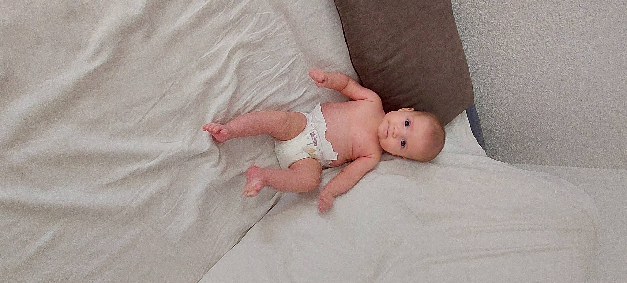 Charlotte a rejoint le concours — aidez-le/la à gagner de superbes lots ! baby, baby_toddler_clothing, bedding, child, comfort, eye, face, finger, flash_photography, flesh, flooring, foot, human_leg, linens, pattern, person, room, sitting, skin, toddler