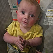 Noah joined the competition — help win amazing prizes! baby, infant, child, portrait, sitting, yellow_clothing, wide_eyes, facial_expression, hands, arms, indoors, nursery, baby_seat, cushion, rainbow, monkey, colorful_background, close_up, adorable, photography