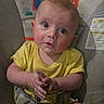 baby, infant, child, portrait, sitting, yellow_clothing, wide_eyes, facial_expression, hands, arms, indoors, nursery, baby_seat, cushion, rainbow, monkey, colorful_background, close_up, adorable, photography