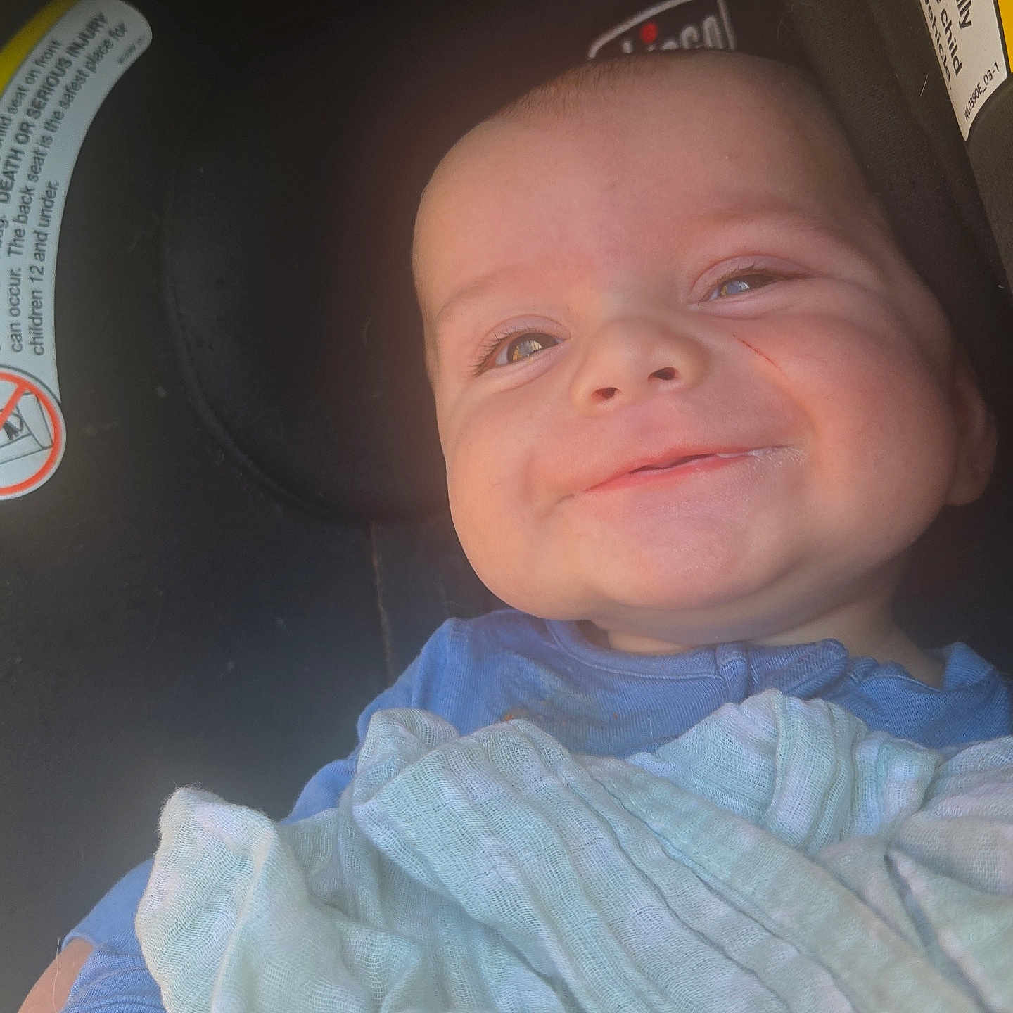 Noah is registered to the contest to win money with this photo: baby, infant, child, smiling, face, portrait, car_seat, blanket, blue_clothing, indoor, close_up, happy, eyes, nose, mouth, head, seated, automobile, baby_photo, cozy