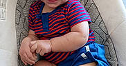 Harper joined the competition — help win amazing prizes! baby, child, smiling, striped_shirt, blue_shorts, baby_seat, cushion, indoor, happy, infant, person, cute, legs, feet, hands, face, portrait, casual, young, playful