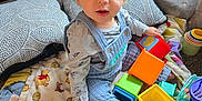 Logan joined the competition — help win amazing prizes! toddler, child, toys, blanket, winnie_the_pooh, indoor, playing, colorful, curious, blue_eyes, overalls, soft_toys, basket, floor, carpet, pillow, pink_blanket, cute, expression, young_child