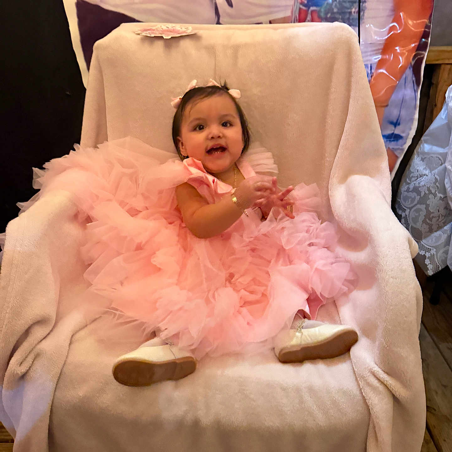 Mia joined the competition — help win amazing prizes! baby, child, pink_dress, chair, blanket, party, celebration, smile, happy, indoor, footwear, person, portrait, cute, toddler, decorations, wooden_floor, jewelry, ribbon, fabric