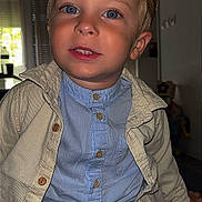 Thiago participe au concours pour gagner de l'argent avec cette photo : child, boy, portrait, indoor, blue_eyes, smile, jacket, shirt, buttons, seated, face, hair, light, window, background, furniture, young, casual_clothing, happy, person