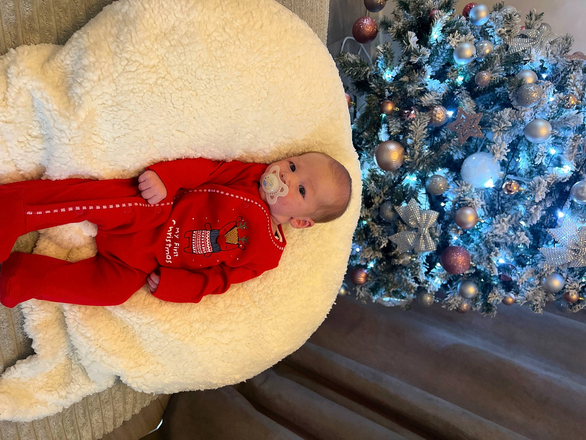 Freddie is registered to the contest to win money with this photo: baby, baby_sleeping, baby_toddler_clothing, child, christmas, christmas_eve, christmas_ornament, christmas_tree, comfort, couch, event, hat, head, human_body, outerwear, person, santa_claus, textile, toddler, tree