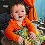 Eloise joined the competition — help win amazing prizes! baby, cake, messy, highchair, orange_clothing, smiling, face, hands, frosting, colorful, indoor, celebration, child, happy, food, birthday, decorations, curtain, cobweb, person