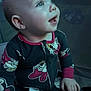 Imogen is registered to the contest to win money with this photo: baby, child, pajamas, stuffed_animal, indoor, portrait, smiling, happy, infant, toy, cute, face, hand, seated, clothing, person, young_child, expression, looking_up, cozy