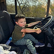 Jesse joined the competition — help win amazing prizes! child, boy, steering_wheel, car_interior, seat, sneakers, window, sunlight, smartphone, paper_towel, casual_clothing, playful, vehicle, seatbelt, dashboard, seat_cover, grip, daylight, smile, indoor