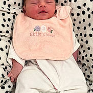 Elisa a rejoint le concours — aidez-le/la à gagner de superbes lots ! newborn, baby, sleeping, bib, pink, white_clothing, polka_dot, cushion, infant, cute, soft_texture, resting, peaceful, portrait, child, small_hands, indoors, cozy, fabric, toddler