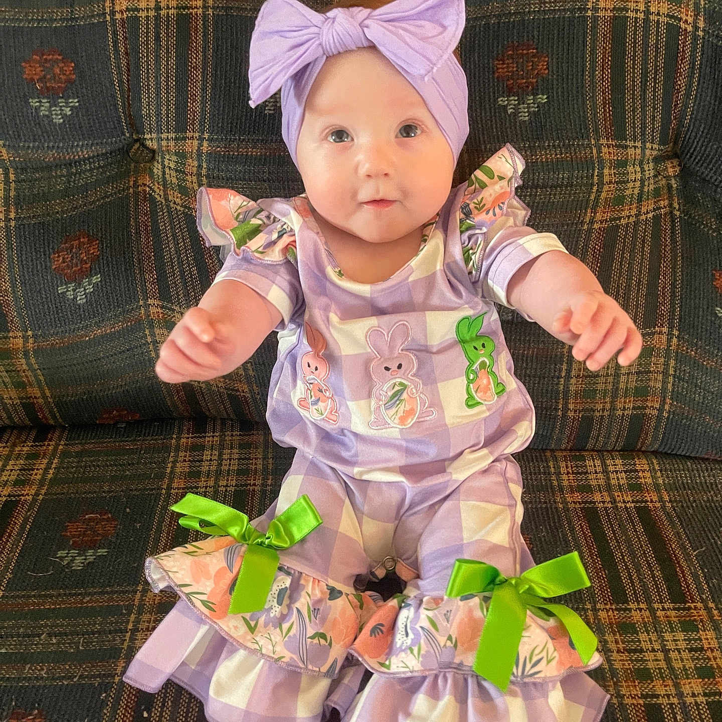 Ayvianna joined the competition — help win amazing prizes! baby, bunny_prints, child, clothing, couch, cute, feet, furniture, green_bows, hands, happy, headband, indoors, infant, person, plaid_pattern, portrait, purple_outfit, sitting, smiling