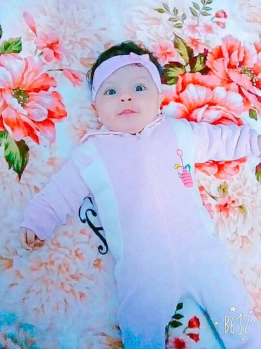 Natalie is registered to the contest to win money with this photo: baby, baby_toddler_clothing, cut_flowers, dress, flower, grass, happy, head, headwear, lip, pattern, peach, people_in_nature, person, petal, pink, plant, rose_family, sleeve, textile