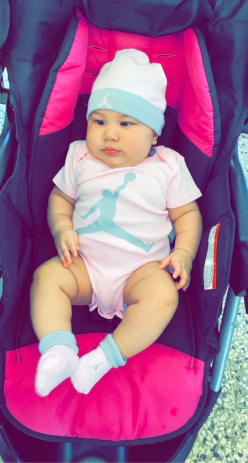 Lilian joined the competition — help win amazing prizes! baby, baby_carriage, baby_toddler_clothing, baseball_cap, beauty, cap, child, comfort, facial_expression, fun, happy, headwear, lap, magenta, person, pink, product, purple, shorts, sitting