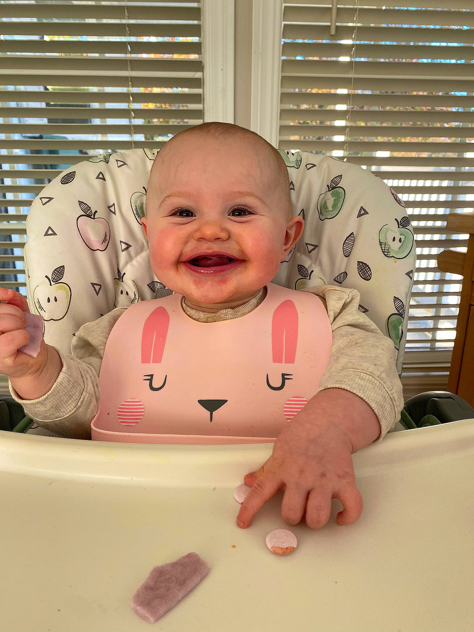 Nora is registered to the contest to win money with this photo: baby, baby_grabbing_for_something, baby_laughing, baby_safety, baby_toddler_clothing, cheek, child, comfort, finger, fun, happy, joy, mouth, person, pink, skin, sleeve, smile, table, thumb