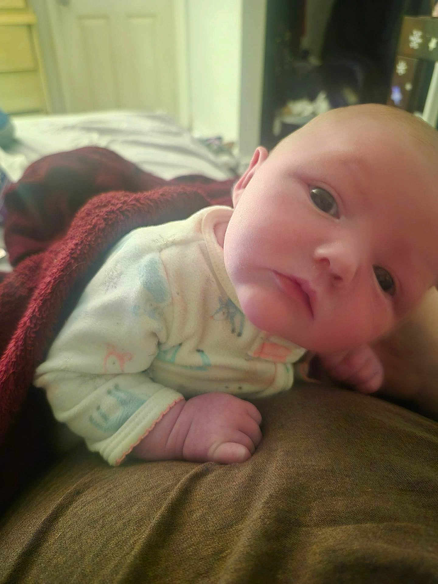 Renesmee is registered to the contest to win money with this photo: baby, infant, blanket, clothing, face, hand, indoor, portrait, cute, newborn, bed, sleepwear, young_child, skin, expression, lying_down, soft_lighting, warm_colors, child, person