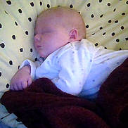 Renesmee is registered to the contest to win money with this photo: baby, sleeping, blanket, pillow, polka_dot, infant, cozy, bedroom, rest, soft_lighting, child, peaceful, cute, portrait, indoors, person, sleep, clothing, hand, head