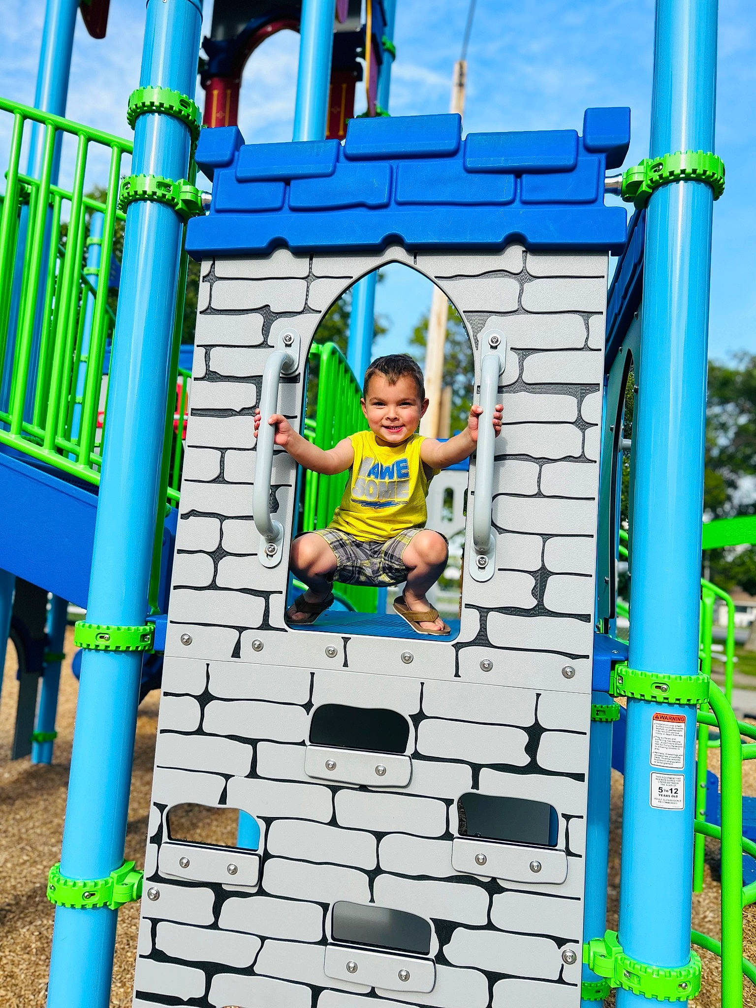 Cohen is registered to the contest to win money with this photo: azure, blue, child, chute, city, electric_blue, fun, joy, leisure, nature, outdoor_play_equipment, person, play, playground, recreation, shorts, sky, smile, summer, symmetry