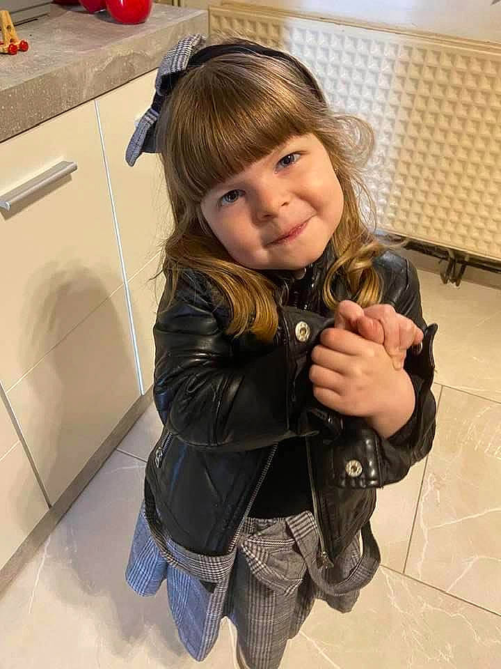 Ofélia participe au concours pour gagner de l'argent avec cette photo : bangs, blond, brown_hair, child, flooring, fun, glove, hairstyle, happy, home_appliance, jacket, joy, kitchen, kitchen_appliance, person, skin, sleeve, smile, standing, street_fashion