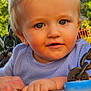Anthony-Junior is registered to the contest to win money with this photo: baby, blue_clothing, child, curly_hair, cute, daylight, face, greenery, hand, happy, metal_chain, metal_handle, nature, outdoor, person, playground, portrait, smiling, swing, toddler