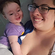 Daniel is registered to the contest to win money with this photo: baby, woman, glasses, smile, indoor, embrace, purple_shirt, skin, face, person, happy, child, closeup, holding, affection, casual, family, portrait, love, together